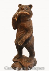 Urso da Floresta Negra e estátua esculpida de salmão.